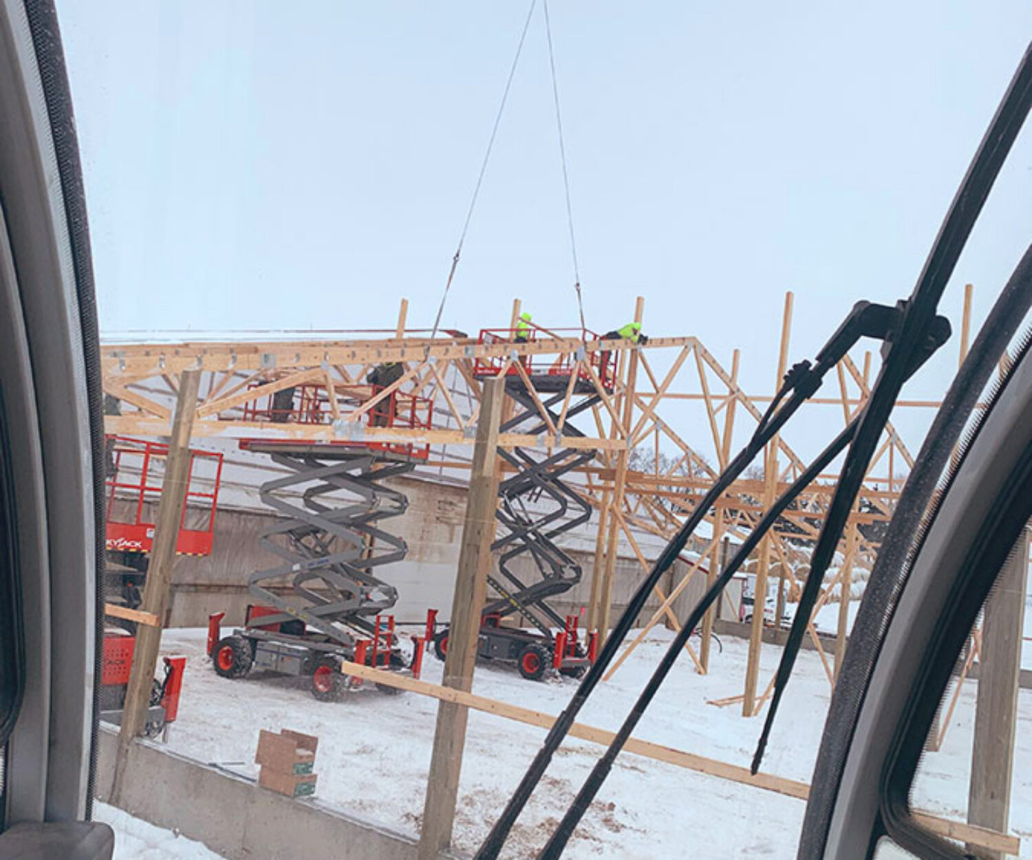 Crane service setting 2-piece trusses on pole barn.