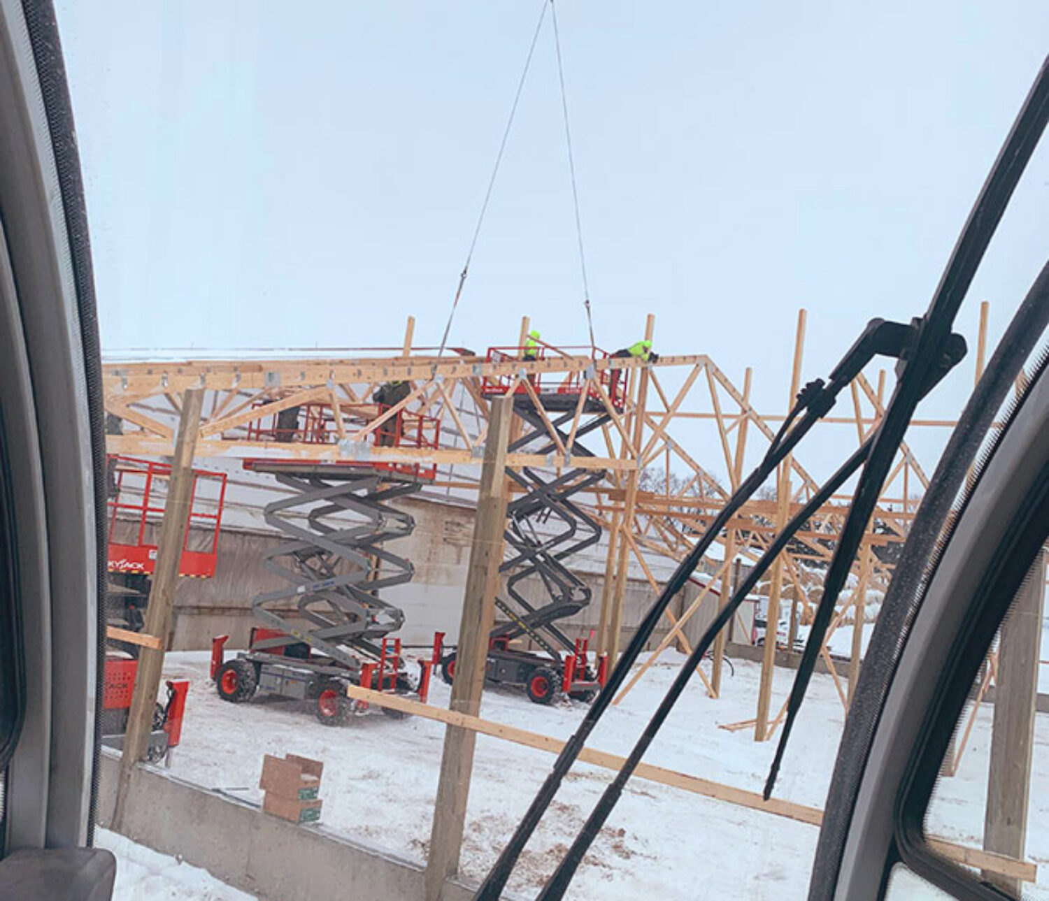 Crane service setting 2-piece trusses on pole barn.